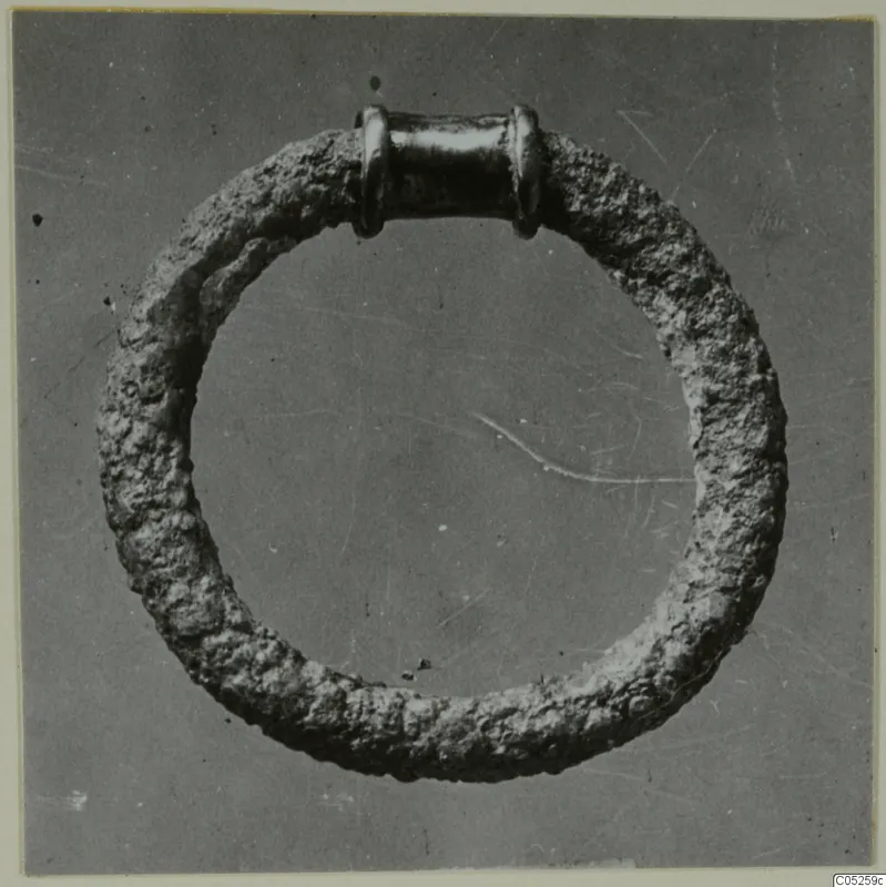 Ring with a thick, corroded hoop and a smooth tubular section with collars, from Ayios Iakovos