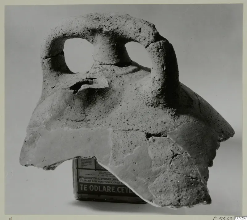 Fragment of coarse hand-made pottery with a thick loop handle pierced by two holes
