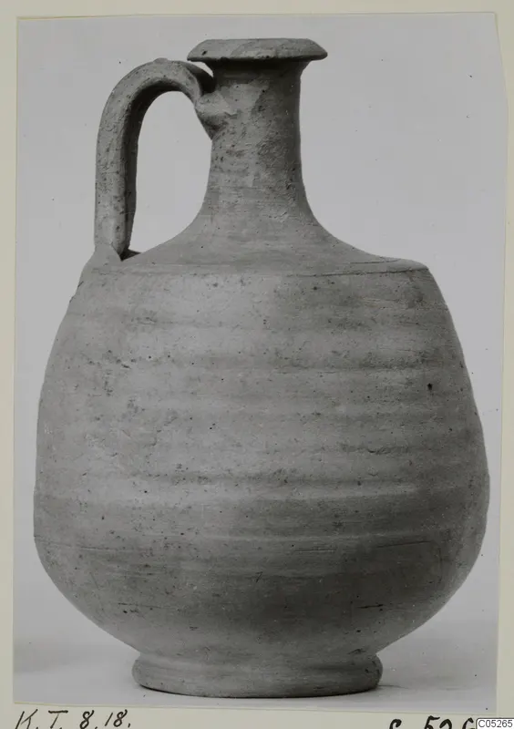 Grey pottery jug with a single strap handle and a flat, overhanging rim