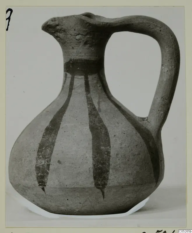Pottery jug with a single loop handle and dark painted vertical stripes running down a pale body