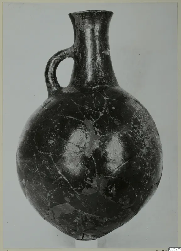 Pottery jug with a single loop handle, tall flaring neck and rounded body, from the Vrysi tou Barba tombs at Lapithos