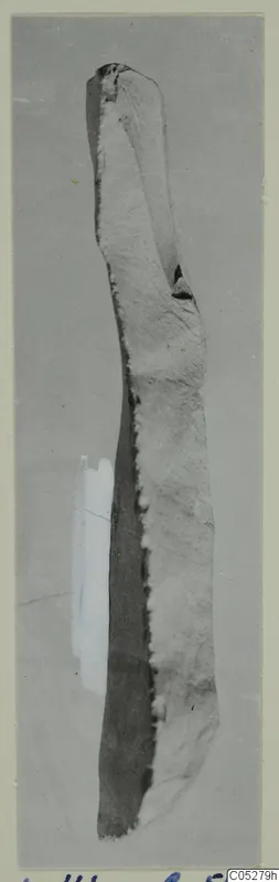 Elongated stone object from Kythrea, shown upright on a grey card mount.