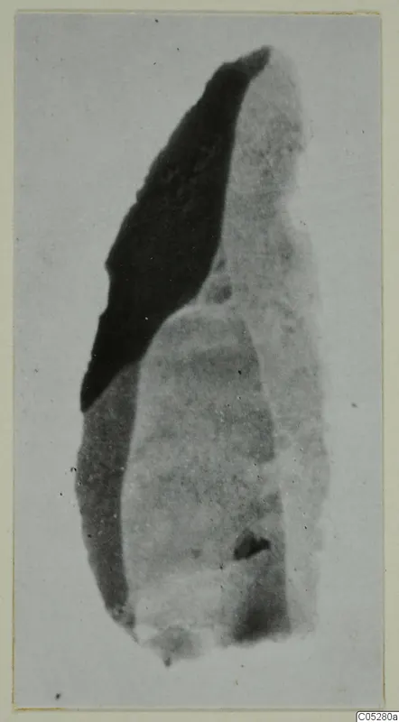 Stone object from Kythrea: an elongated fragment, dark on one side and pale grey on the other