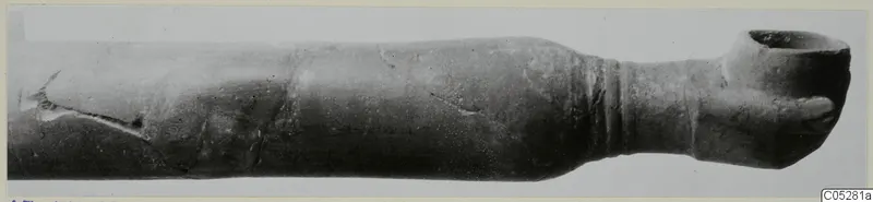 Red Lustrous Ware vessel with a long body and wide flared mouth, photographed lying horizontally, from Ayios Iakovos