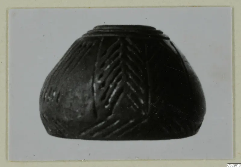 Small dark vessel with a stepped rim and incised chevron pattern on its body