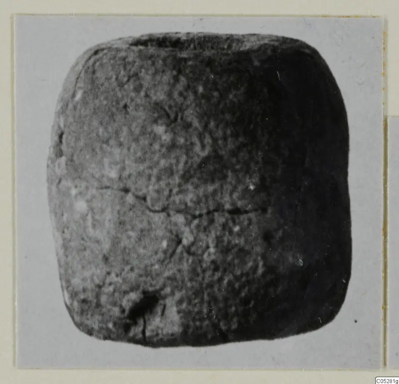 Small dark object with rounded corners, from the Vrysi tou Barba tombs at Lapithos