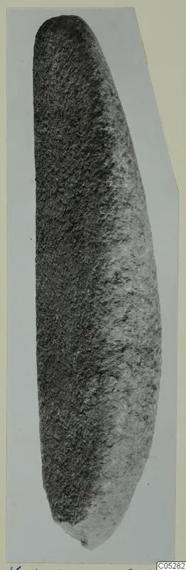 Grinder of stone from Kythrea, long and slightly curved, rounded at the top and tapering to a narrower rounded end.