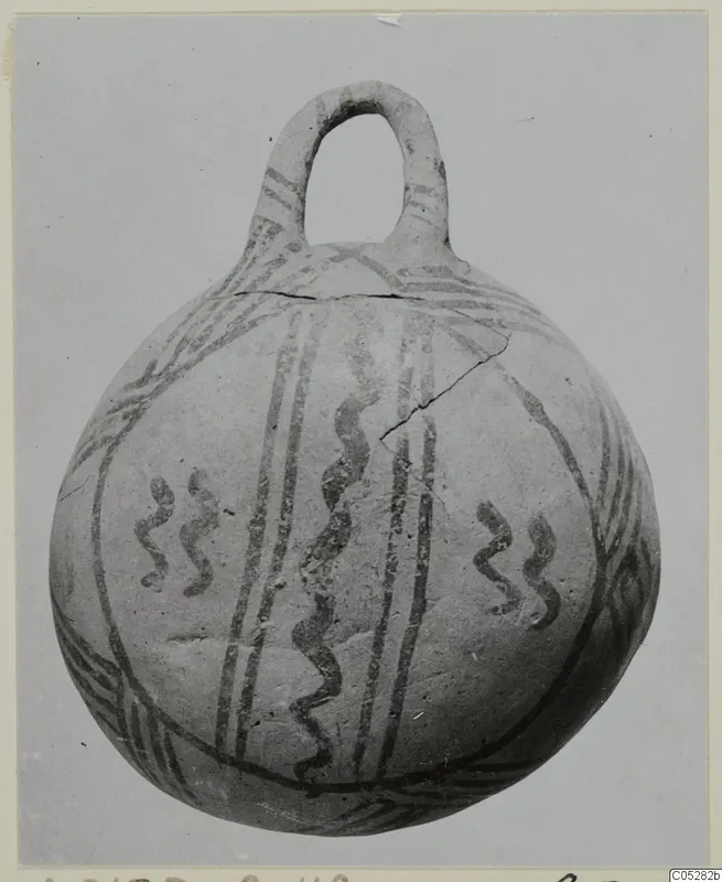 Round pottery vessel with a loop handle, decorated with dark painted bands and wavy lines, White Painted III-2