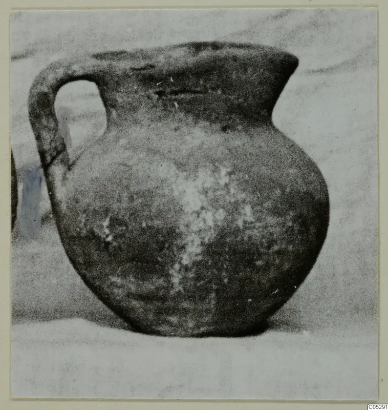 Round-bodied jug with a single strap handle and a flaring rim, shown on a pale surface