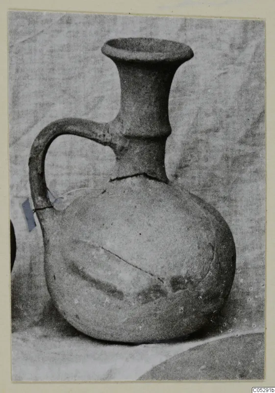Pottery jug with a wide flaring mouth and strap handle, Plain White I-III, from Lapithos Kastros tombs.