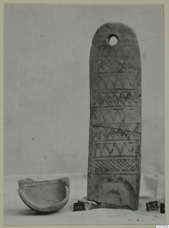 Pottery White Painted III-1 with a hole near its rounded top, shown beside a broken bowl