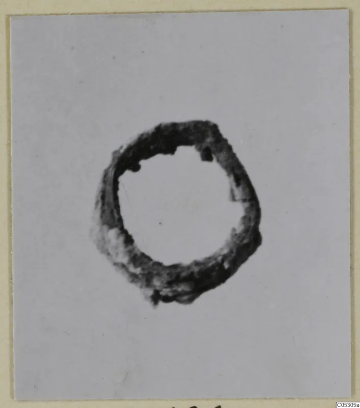 Corroded bronze ring from Lapithos, shown centred on a pale card background.