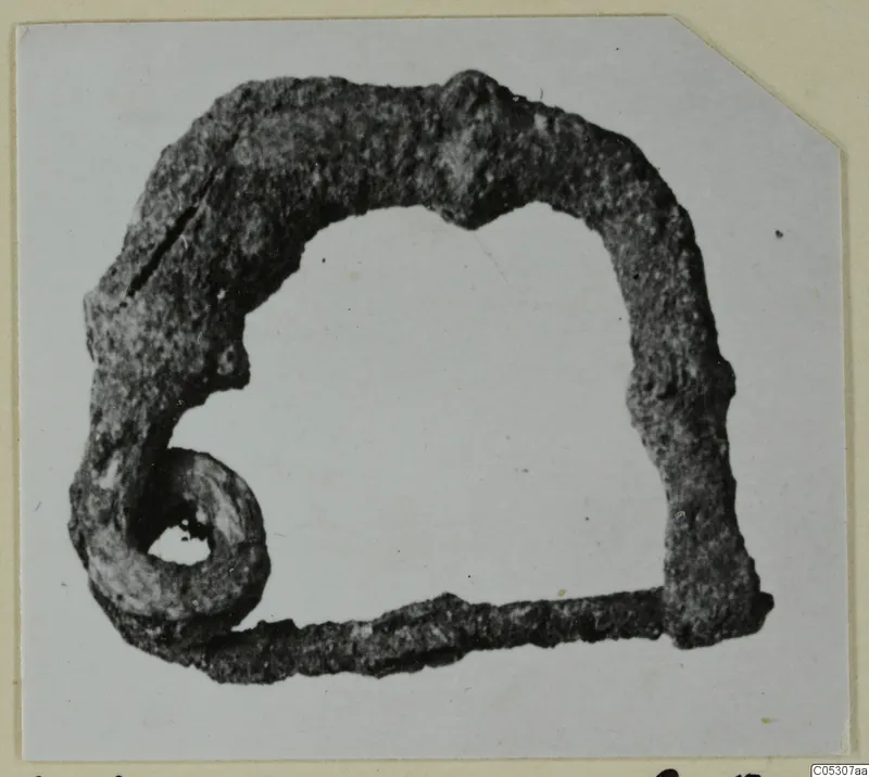 Corroded bronze loop with a rolled spiral end, from Lapithos Kastros tombs.