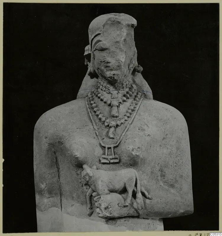 Limestone statue bust with a beaded necklace and a small sculpted animal at its chest.