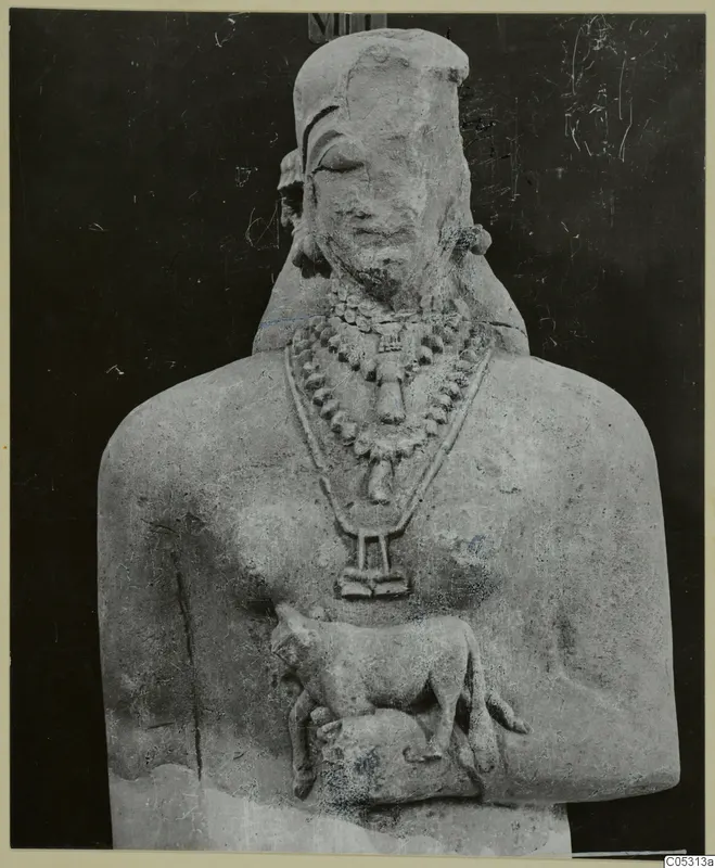 Limestone statue bust with layered bead necklaces and a small animal carved at the chest