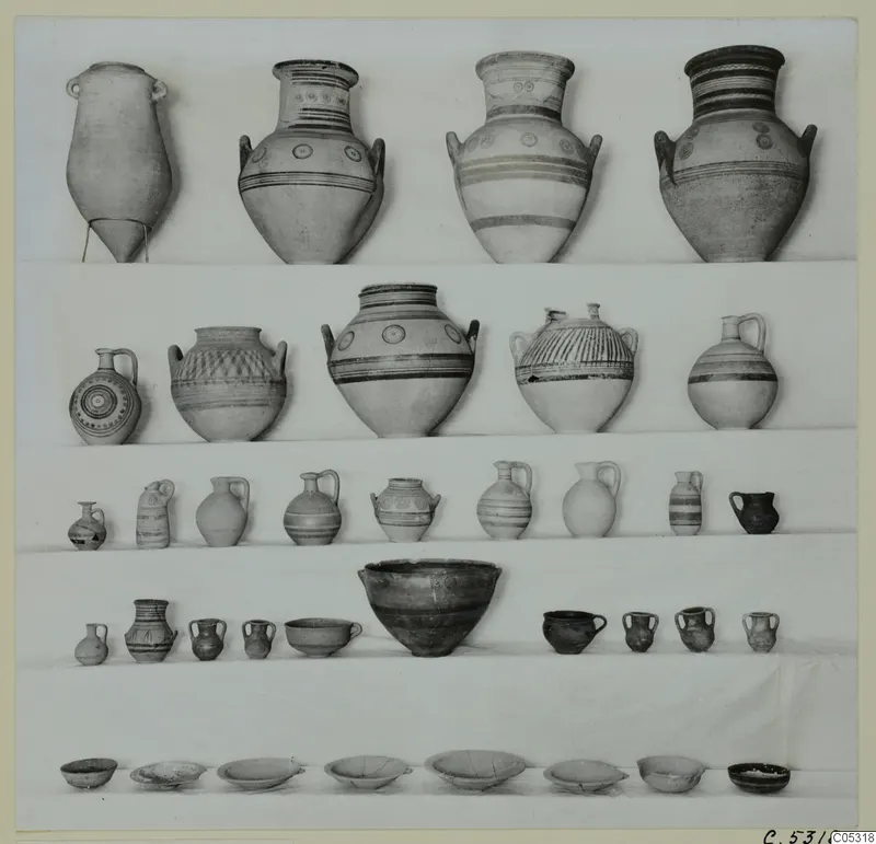Pottery from Marion, Tomb 82: rows of jars, jugs, cups and bowls set out on a pale background.