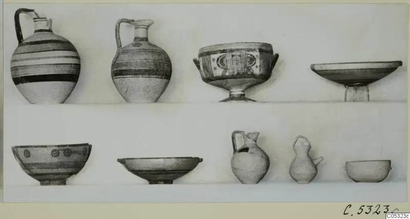 Nine vessels from Stylli T. 2-17, jugs, footed bowls and small pots arranged in two rows