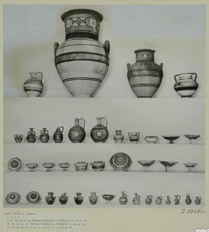 Pottery vessels from Tomb 17 at Stylli, arranged in rows on shelves against a pale background
