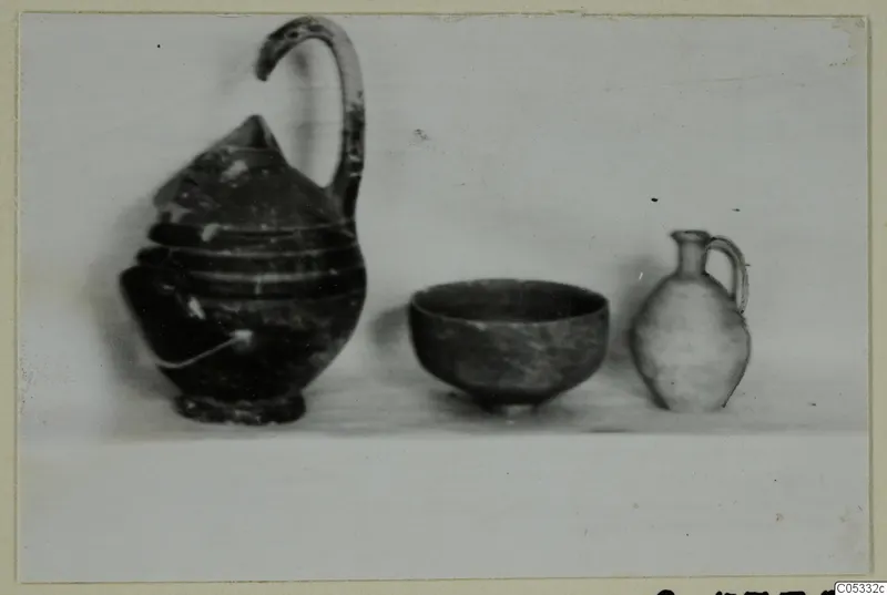 Pottery from Marion Tomb 24: a jug, a bowl and a small juglet standing side by side on a pale surface.