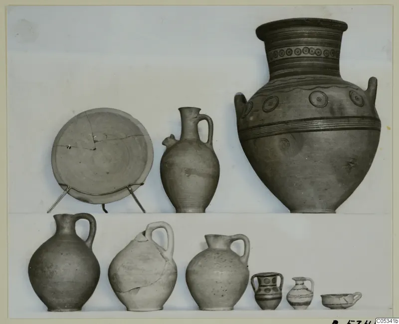 Group of pottery vessels from Marion, Tomb 85, including a large two-handled jar and several jugs and a plate.
