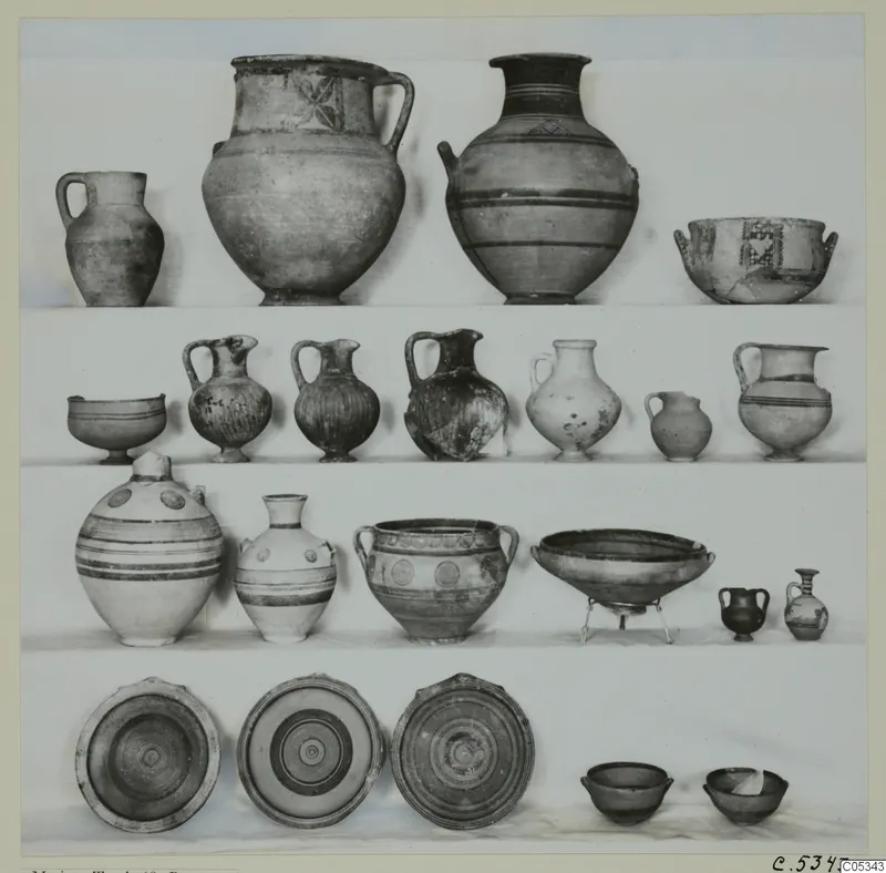 Pottery vessels from Marion Tomb 68 arranged in four rows: jugs, jars, bowls and plates.
