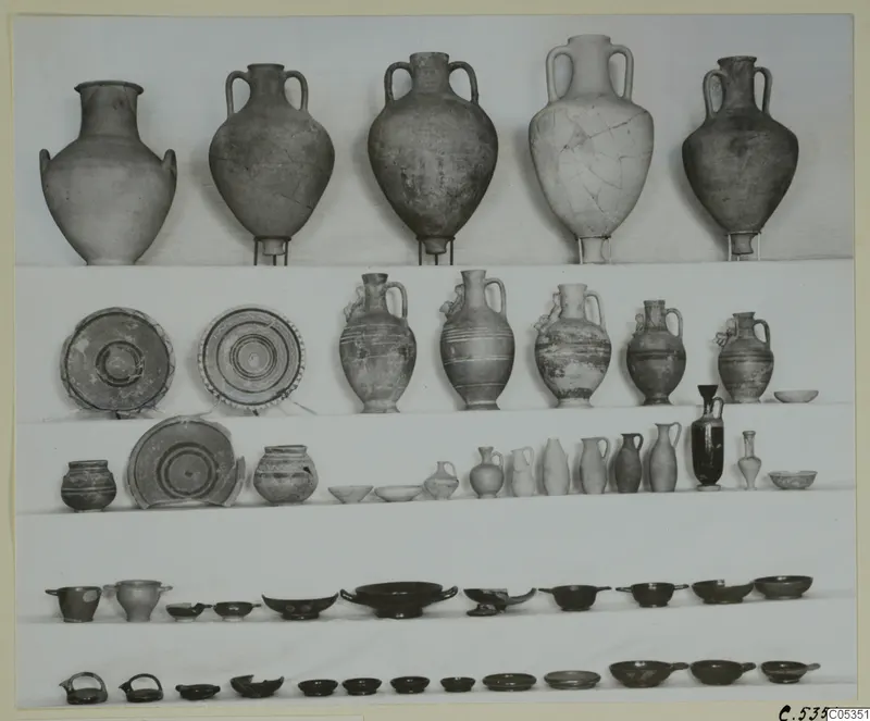 Pottery from Tomb 58 at Marion: jars, jugs, plates and small bowls arranged in rows on shelves