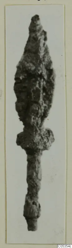 Corroded iron weapon with a leaf-shaped blade, a shoulder and a long narrow tang.