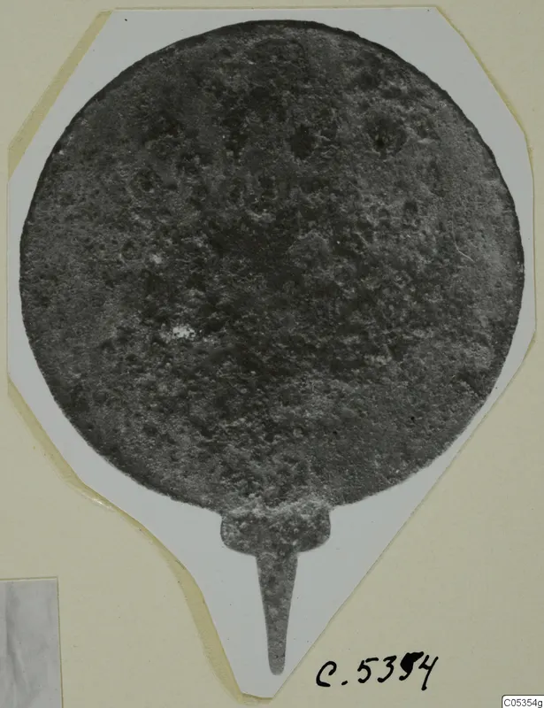 Round metal disc with a narrow tang, from Marion