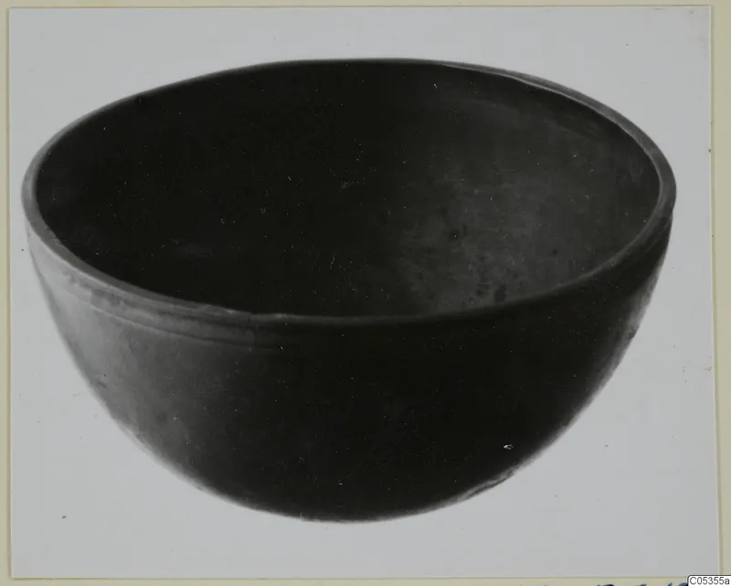 Dark, smooth-walled bowl with a rounded body and a thickened rim.