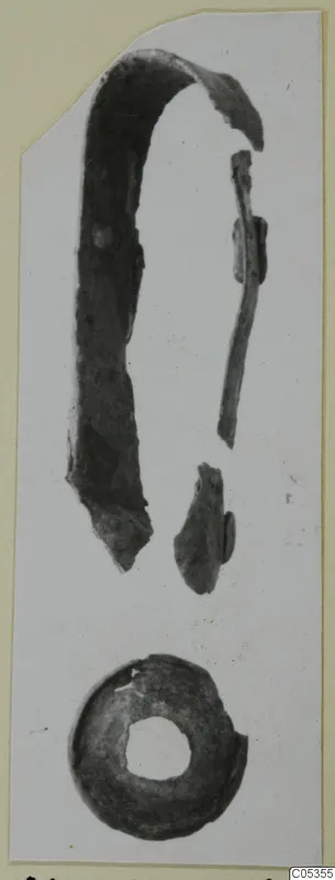 Bronze toilet-requisites from Marion: corroded curved strip, thin rod and fragments, and a ring, shown on a card mount