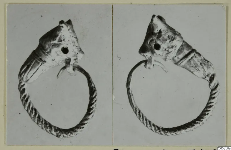 Two photographs of a twisted metal ring ending in a head-shaped terminal, from Marion