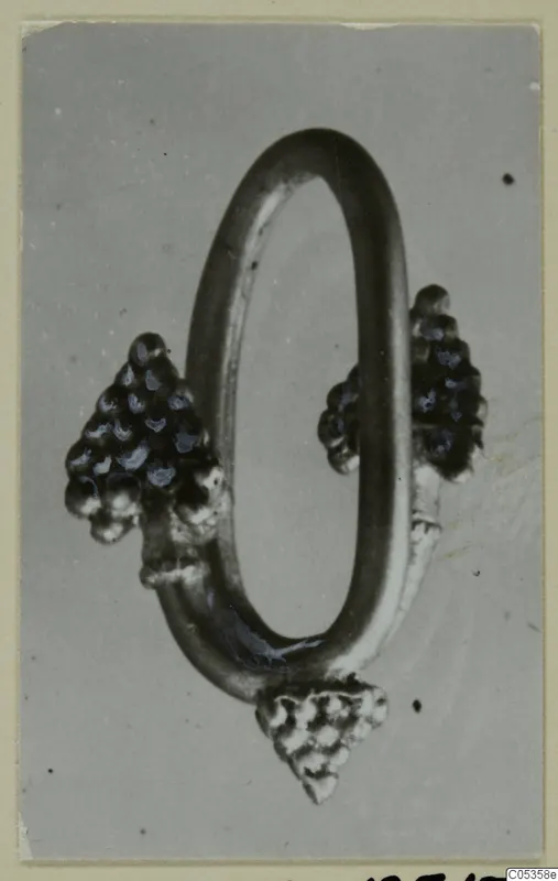 Jewellery from Marion: an oval metal loop with three clusters of small knobs attached