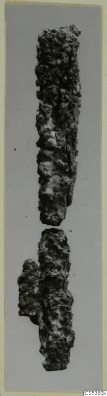 Two corroded iron fragments, probably an iron weapon in two broken pieces, shown on a grey background
