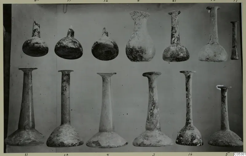 Blown glass vessels from Amathus, twelve pieces arranged in two rows against a plain backdrop