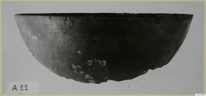 Dark bowl with a wide, rounded body and flat rim, photographed from the side against a pale background, from Amathus