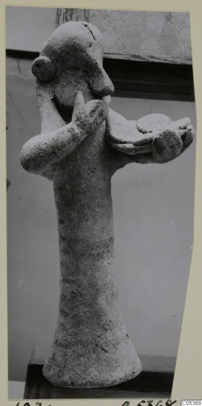 Stone figure from Amathus, one hand raised to its face and the other arm holding out a round object