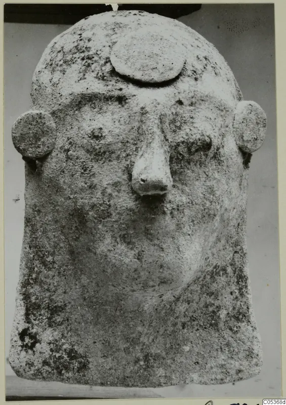 Protome in the form of a human head, with a flat disc on the brow and round ears, from Amathus