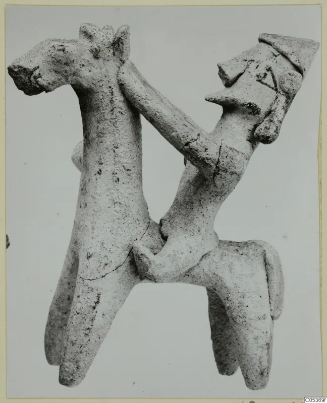 Terracotta figurine of a four-legged animal with a small human figure whose arm reaches over its neck