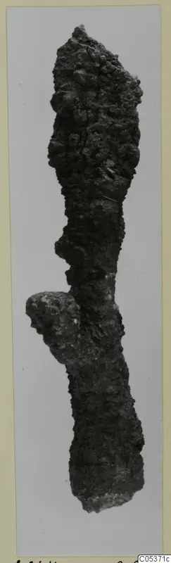 Heavily corroded iron object, elongated with a tapering top and a lobed projection, from the Amathus tomb finds