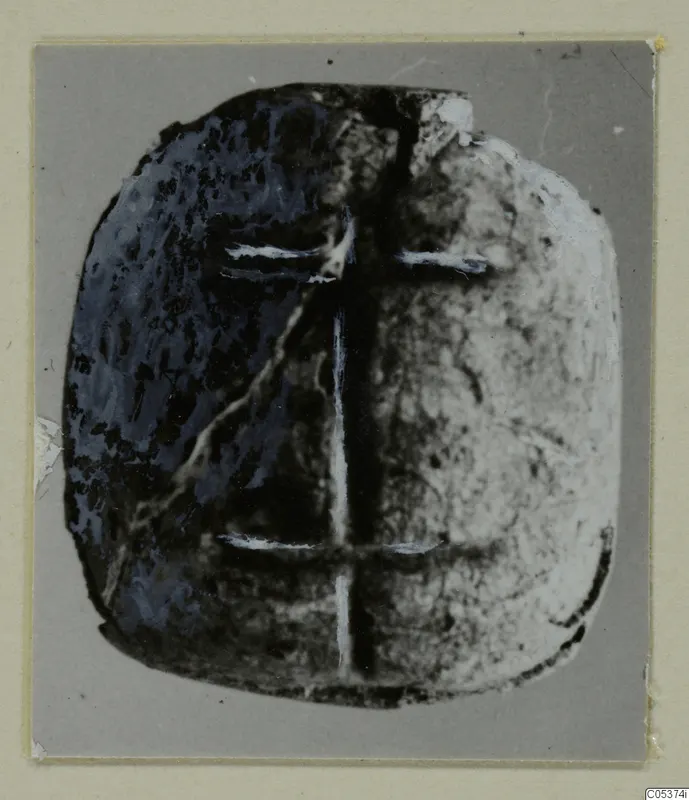 Glyptic from Amathus: a flat, rounded stone seal with a cross-shaped pattern of pale lines.