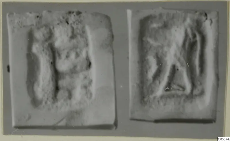 Two seal impressions with raised relief designs, shown side by side against a grey background.