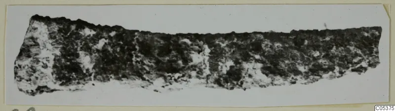 Corroded iron tool fragment from Amathus, a long strip with a crusted, pitted surface.