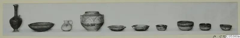 Row of ten pottery vessels from Amathus Tomb 7, including juglets, a large painted jar and small shallow bowls