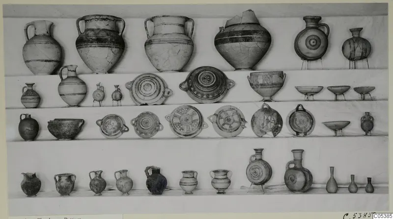Pottery vessels set out in four rows on shelves: jugs, two-handled jars, bowls and small bottles, mostly with painted bands.