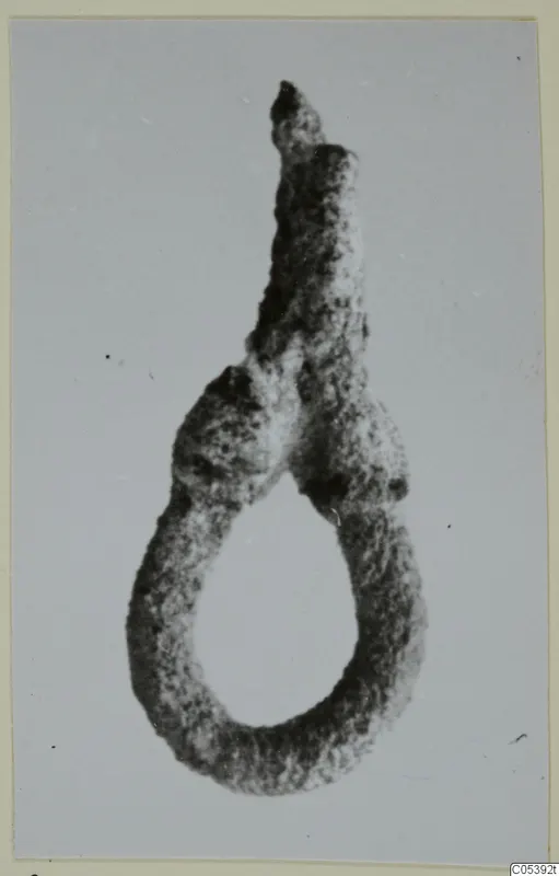 Corroded silver loop-shaped find from Amathus, with a tapering stub rising from the top of the loop