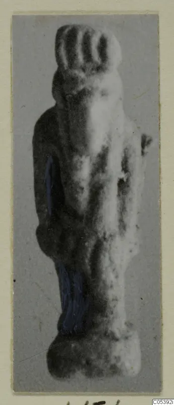 Small standing figurine from Amathus with traces of blue paint, photographed on a grey card mount