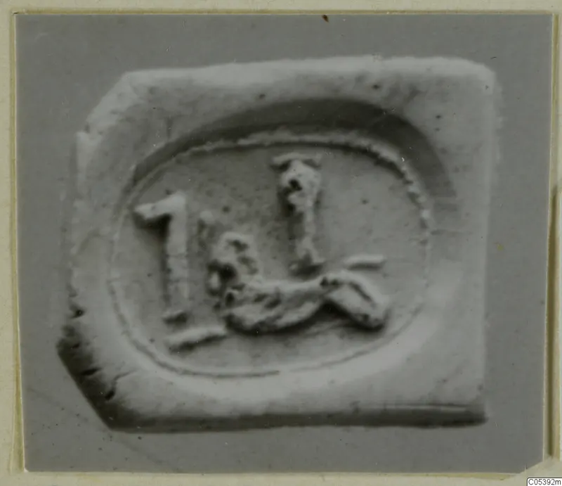 Impression of a seal from Amathus showing a small animal-like figure and an upright sign inside an oval border