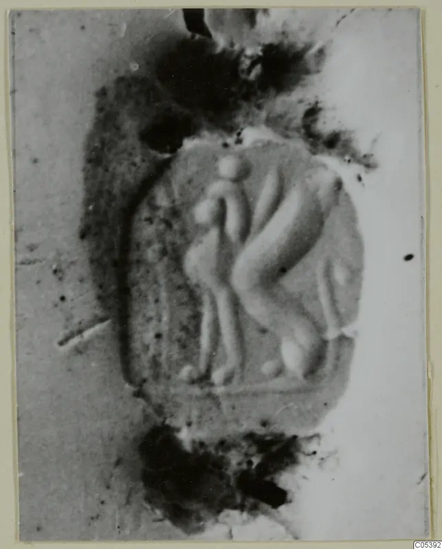 Impression of a scarab from Tomb 62 at Marion, showing raised figures in an oval field