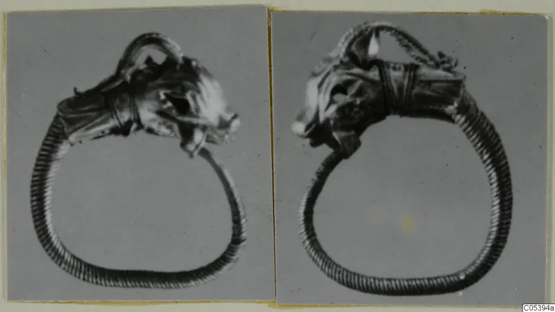 Two photographs of a ring with a head-shaped terminal and ribbed hoop, mounted side by side on a card