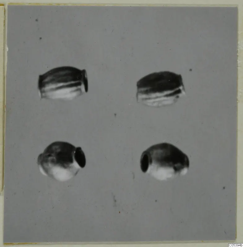 Four small jewellery objects arranged in a two-by-two grid.